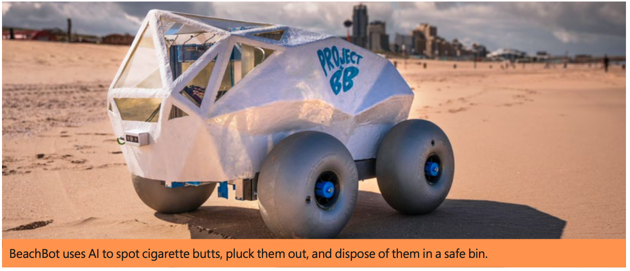 A silver polygonal robot on four large, grey wheels, sits on the beach. Wires and sensors come off the robot, and a number of windows are on the front, making it look a bit like a car.