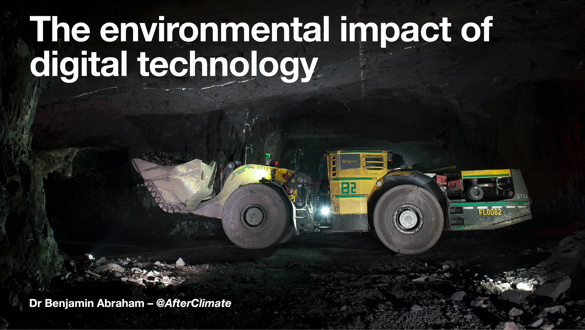 An image of an underground mine, a big yellow loader lifts a bucket of ore, lit only by floodlights from below